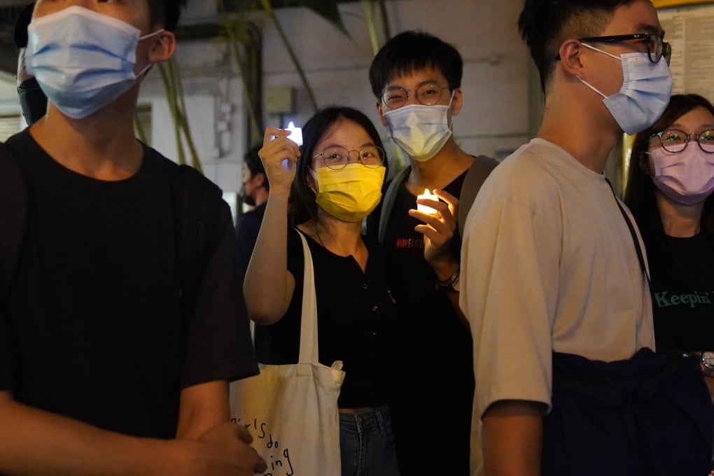 People holding candles stand on the street in Causeway Bay. Photo: Sam Tsang