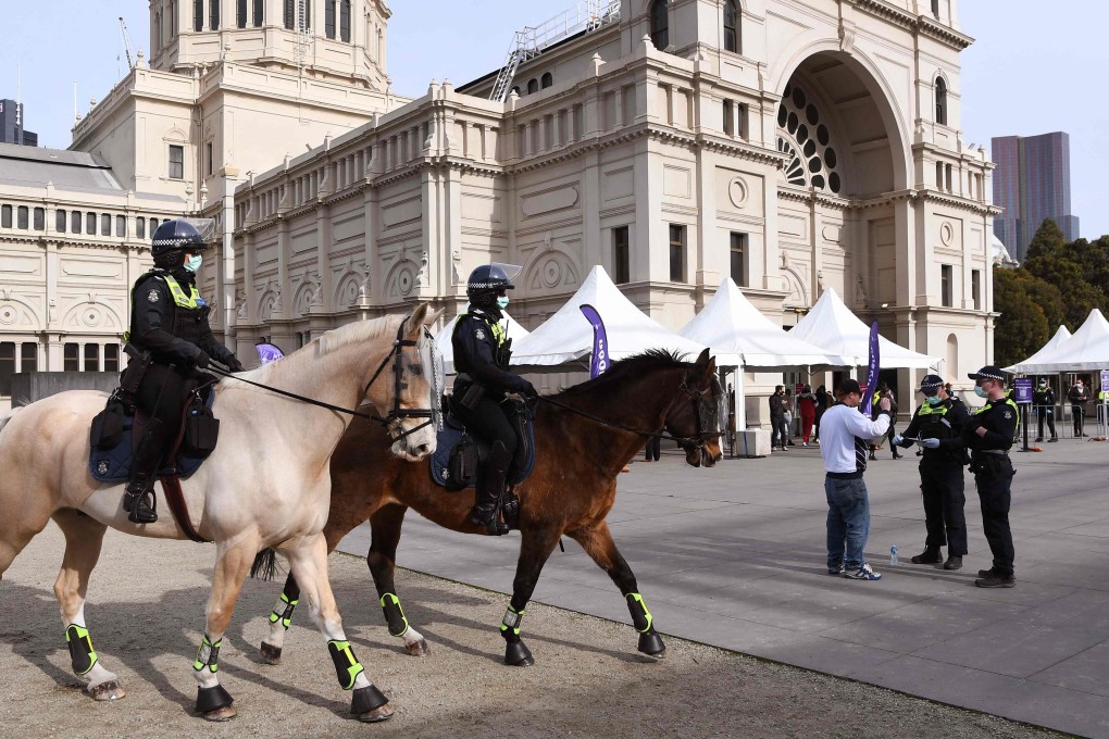 Police patrol a mass vaccination centre in Melbourne. Photo: AFP