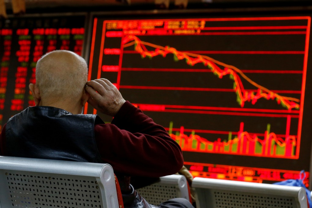 An investor sits in front of a board showing stock information at a brokerage office in Beijing on December 7, 2018. Contrary to global conventions, China denotes gains and advances in red, using green to illustrate declines and losses. Photo: Reuters