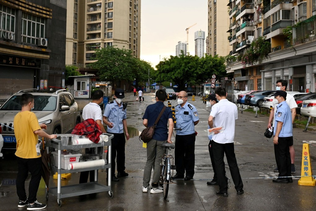 Police officers stop people near a restricted residential area in Liwan district, Guangzhou. Photo: Reuters