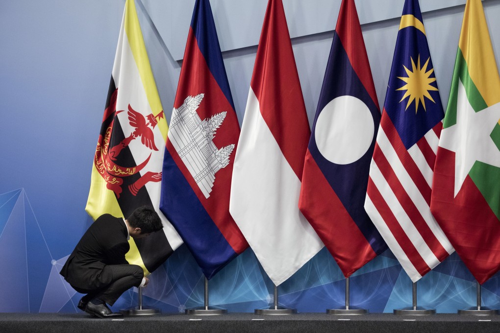 A worker adjusts the Brunei flag before the 22nd Asean coordinating council meeting on the sidelines of the 33rd Asean summit in Singapore in November 2018. Photo: AP