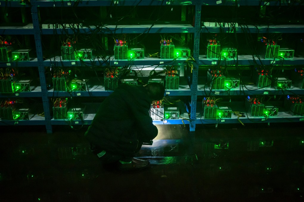 A bitcoin miner inspects a malfunctioning mining machine during his night shift at a mining facility in Sichuan on September 26, 2016. Beijing fears the electricity that massive mining facilities consume could hinder the country’s carbon neutrality goals. Photo: EPA