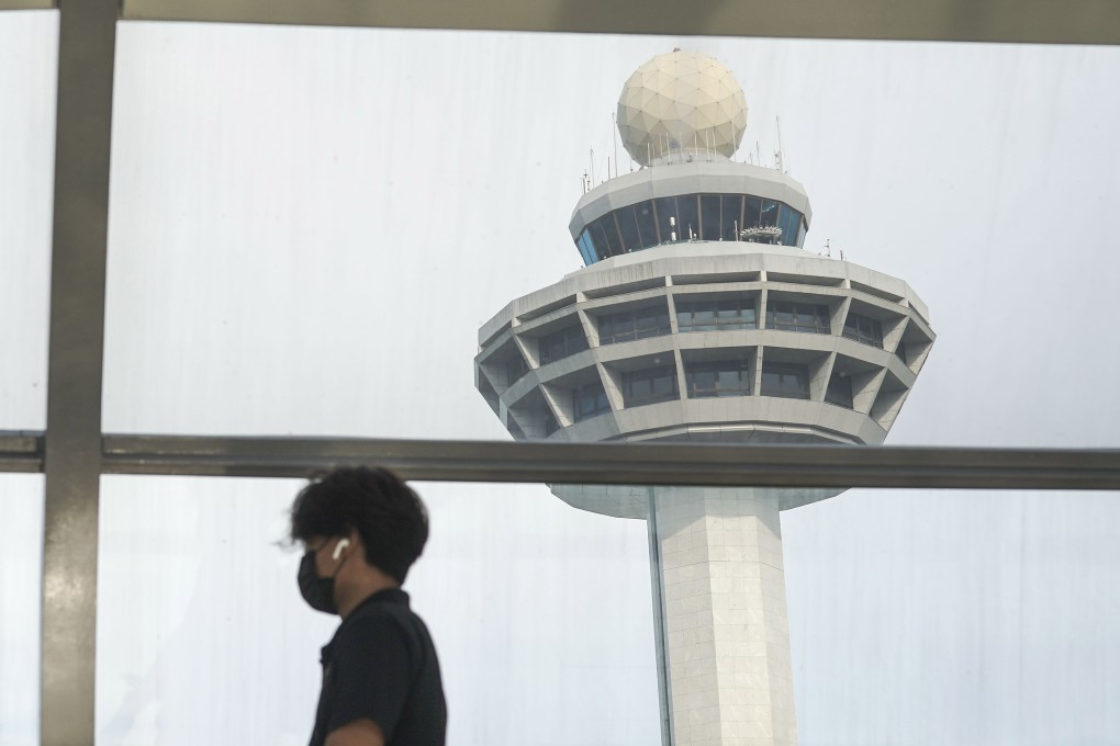 A man passes the control tower of Singapore’s Changi Airport. Photo: EPA