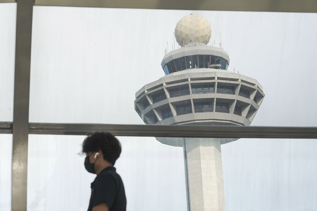 A man passes the control tower of Singapore’s Changi Airport. Photo: EPA