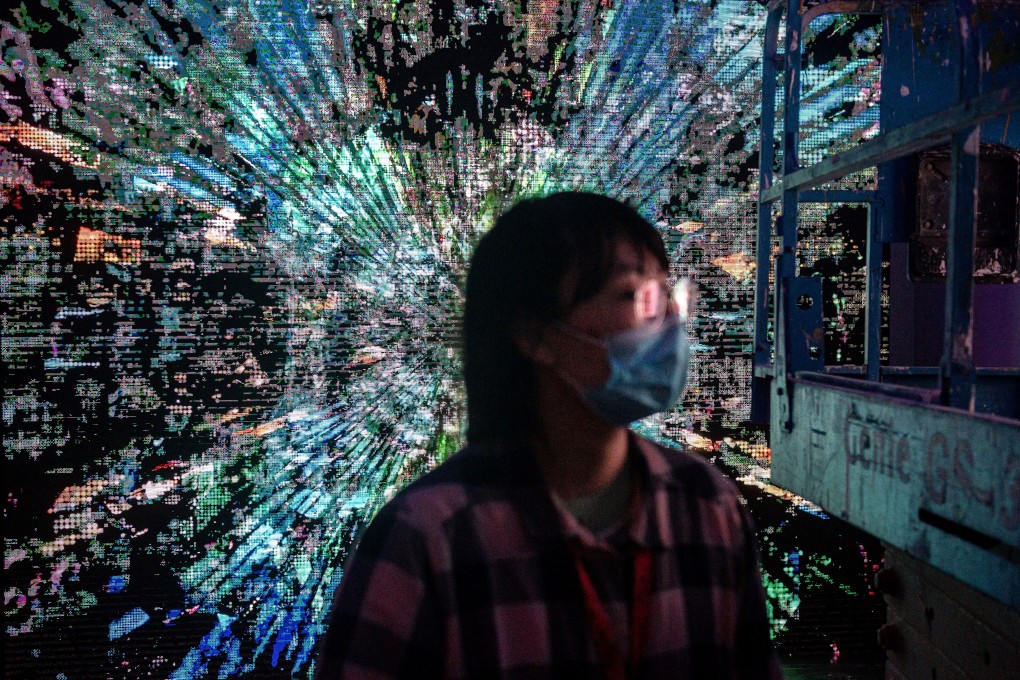 A woman walks in front of a digital painting by Chinese artist Liu Gang at a crypto-art exhibition “Virtual Niche: Have You Ever Seen Memes in the Mirror?", one of the world’s first physical museum shows of blockchain art, ahead of its opening in Beijing on March 26. The coronavirus pandemic has accelerated digitisation across various fields. Photo: AFP