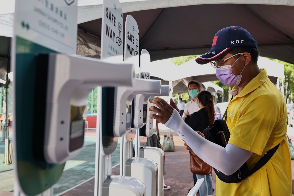 A man wearing a protective face mask sets up thermometer machines at a tennis court, which is being converted into a makeshift vaccination site in Hsinchu, Taiwan, June 8, 2021. Photo: Reuters