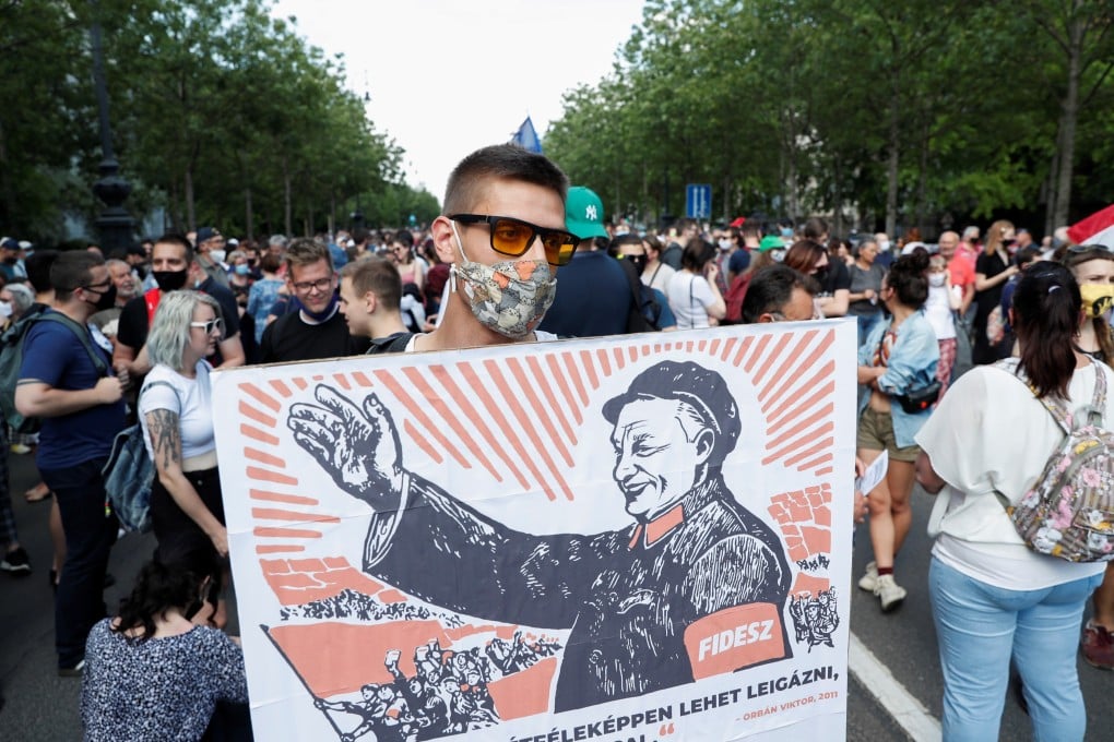 A protester holds a placard depicting Hungary’s Prime Minister Viktor Orban as Mao Zedong during a protest on June 5 against a planned Fudan University campus in Budapest. Photo: Reuters