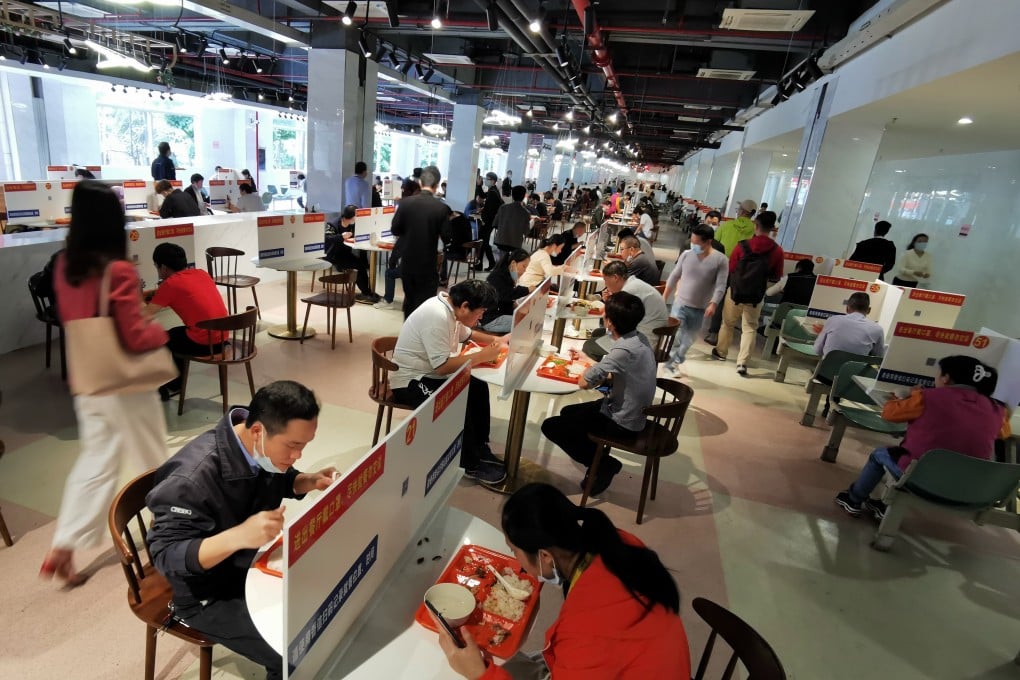 Workers have lunch on tables divided with barriers at a company canteen in the Longhua Science and Technology Park in Shenzhen, in southern China's Guangdong province. Photo: Xinhua