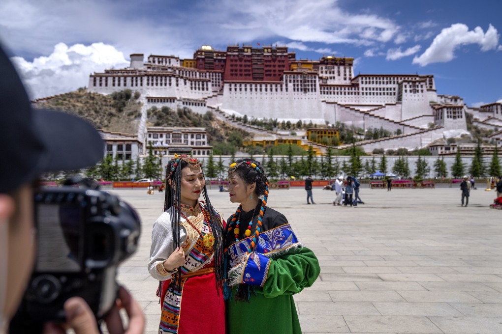 Chinese tourists in Tibetan dress pose for a photo near the Potala Palace in Lhasa. Photo: AP