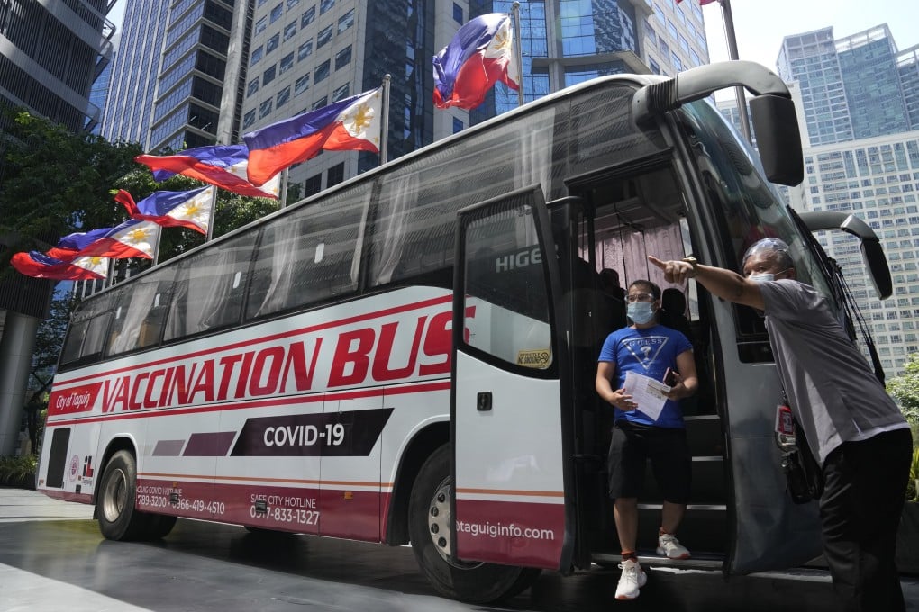 A newly inoculated man exits a bus used as a mobile Covid-19 vaccination centre to encourage people to get vaccinated in Taguig, the Philippines. Philippine authorities have fully vaccinated 2.1 million people, making slow progress towards the target to immunise up to 70 million people this year in a country of 110 million. Photo: AP