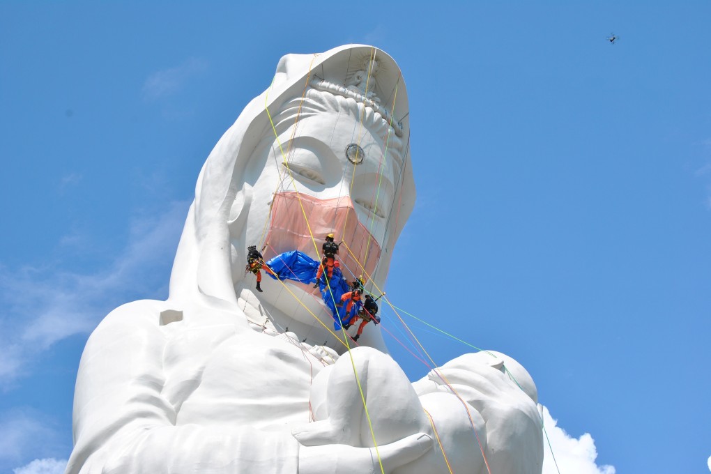 Workers put a mask on a 57 metre Buddhist goddess statue in Aizuwakamatsu, Fukushima prefecture, Japan. Photo: Reuters