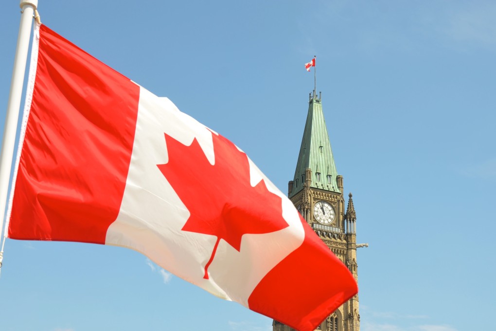 Canadian flag waving in front of the Parliament Building on Parliament Hill in Ottawa. Photo: Unsplash