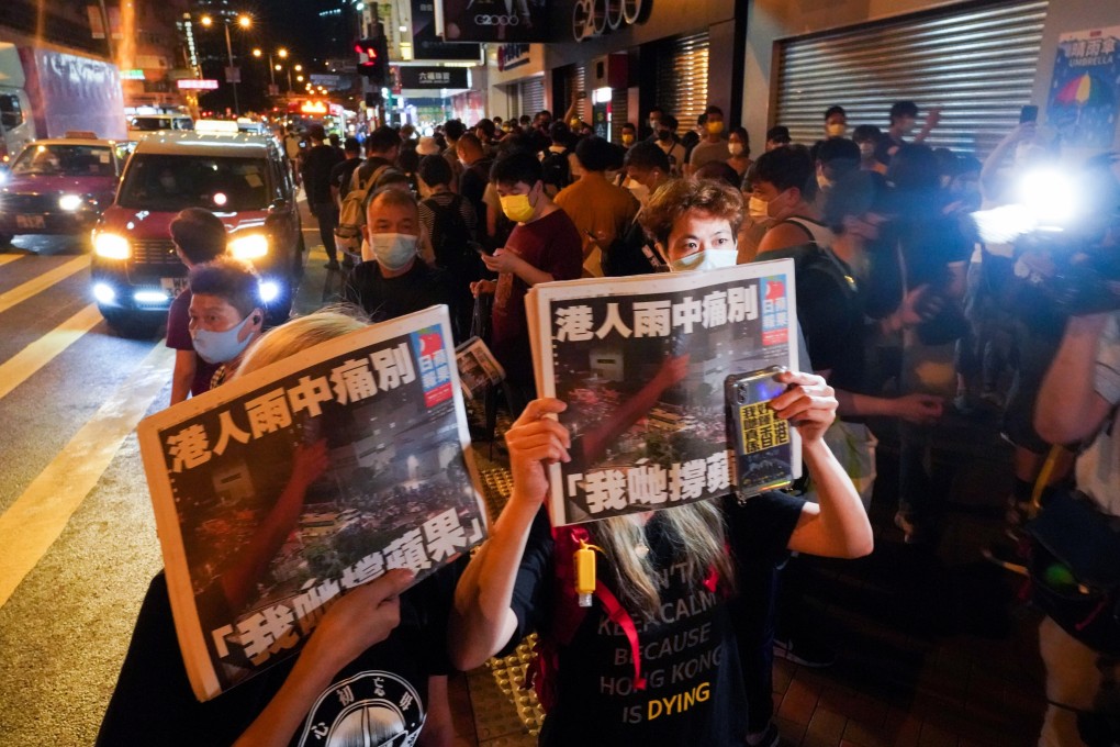 People queue up to buy the last edition of Apple Daily in Mong Kok. The company printed its final edition on Thursday. Photo: Felix Wong