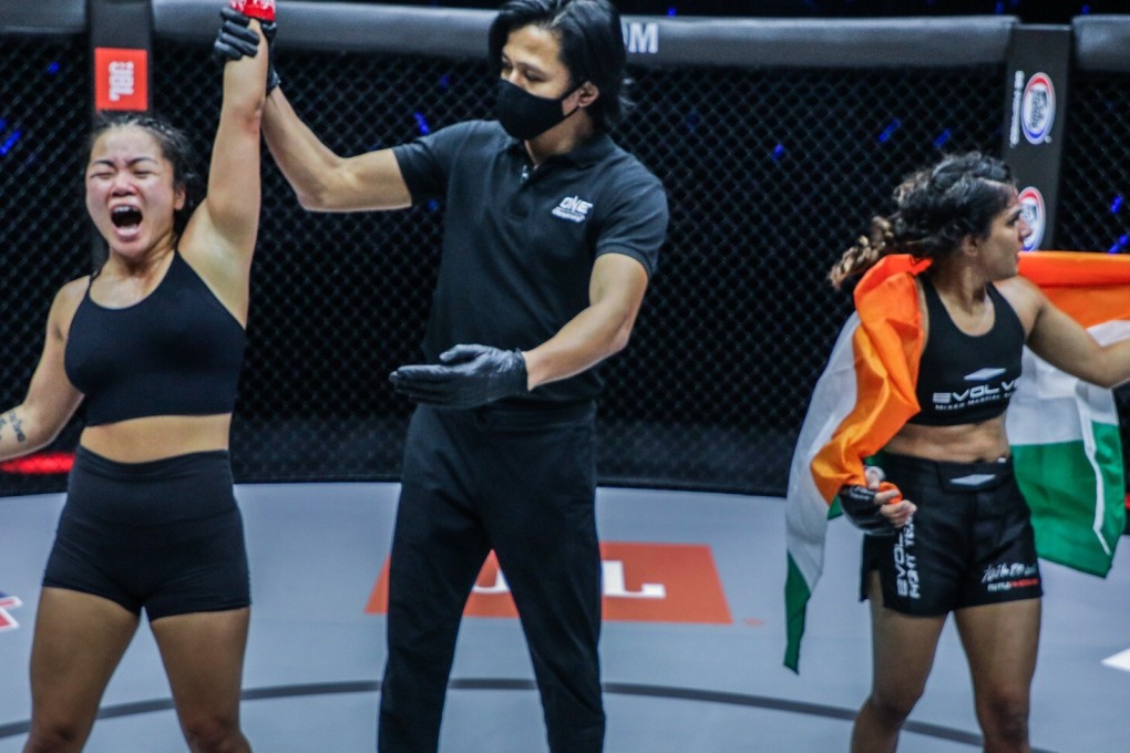 Bi Nguyen celebrates after her arm is raised in victory as Ritu Pogat looks on astonished. Photo: Dux Carvajal/ONE Championship