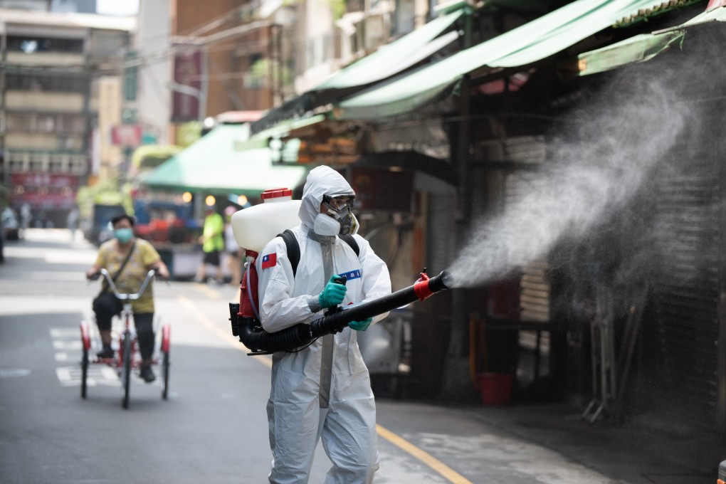 A soldier wearing full protective suit disinfects a public area in Taiwan. Photo: DPA