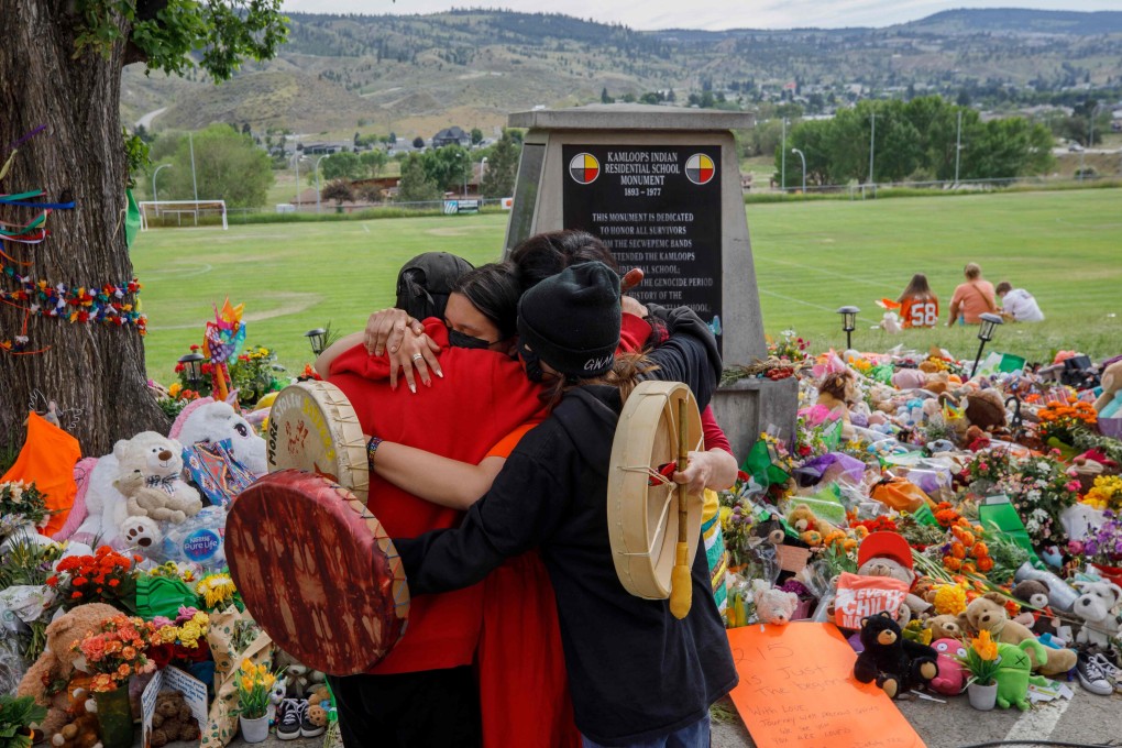 People from Mosakahiken Cree Nation in front of a memorial at the former Kamloops Indian Residential School to honour the 215 children whose remains have been discovered buried near the facility, in Kamloops, British Columbia, Canada on June 4. Photo: AFP