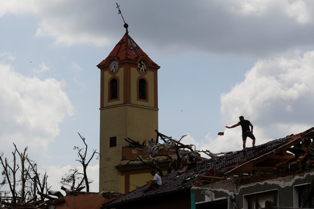 A man throws a tile from a building's rooftop in the aftermath of a rare tornado that struck the Czech Republic. Photo: Reuters