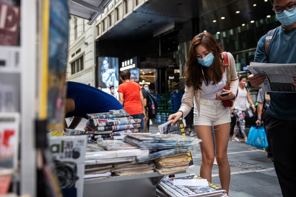 A woman looks at a copy of Apple Daily at a Hong Kong news stand. Photo: EPA-EFE