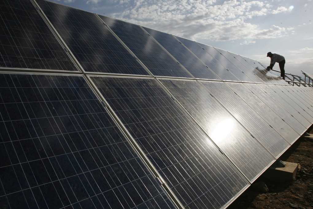 A worker installs solar panels at a farm in Hami, in northwest China's Xinjiang region. Photo: AP