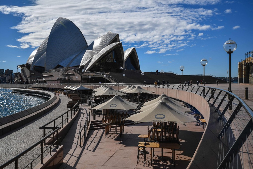 People walk near the Opera House in Sydney on Saturday. Photo: AFP