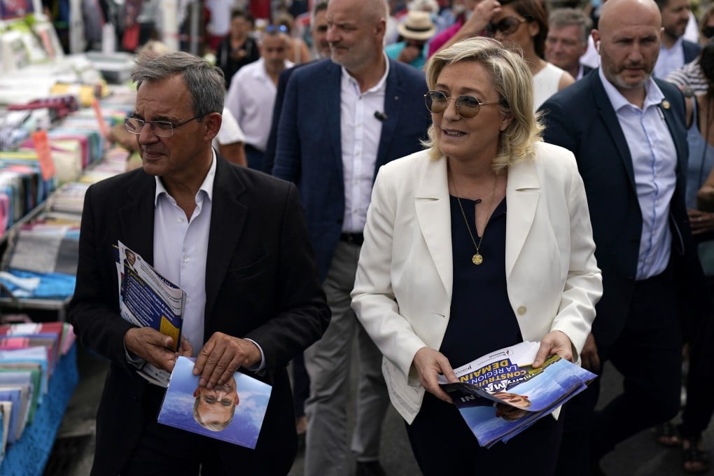 Far-right leader Marine le Pen and local candidate Thierry Mariani (left) campaign at a market in southern France. Photo: AP