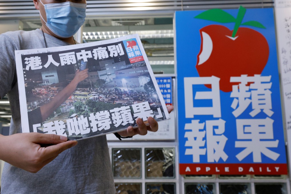 A staff member of Apple Daily poses with his final edition of the newspaper at its headquarters in Hong Kong on June 24, 2021. Photo: Reuters