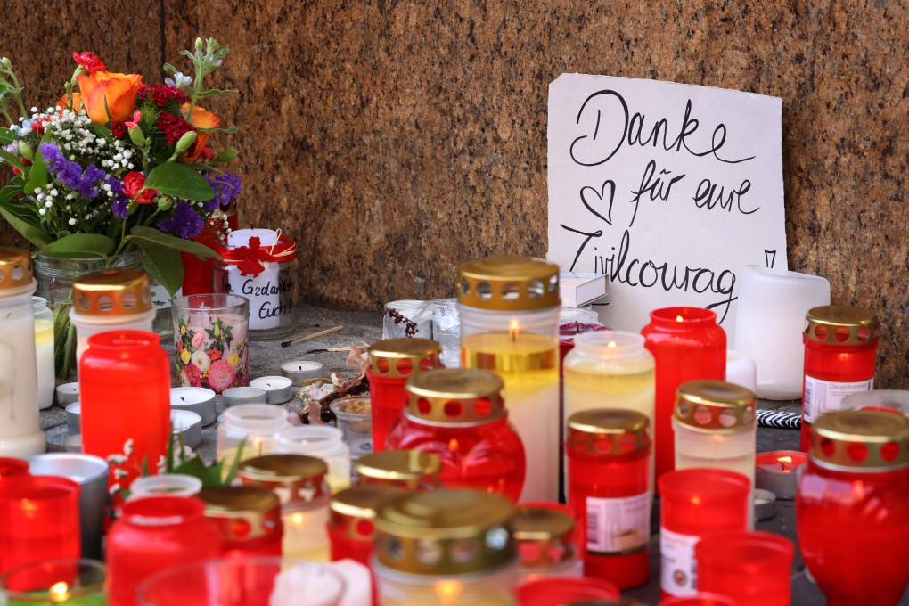 Candles and flowers in front of a department store in downtown Wuerzburg, Germany, where a fatal knife attack took place on Friday. Photo: DPA
