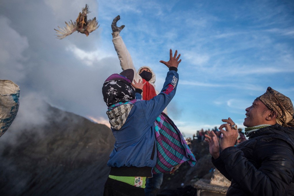 Members of the Tengger tribe throw their offerings into the crater of the active Mount Bromo volcano in Probolinggo, East Java province on Saturday. Photo: AFP