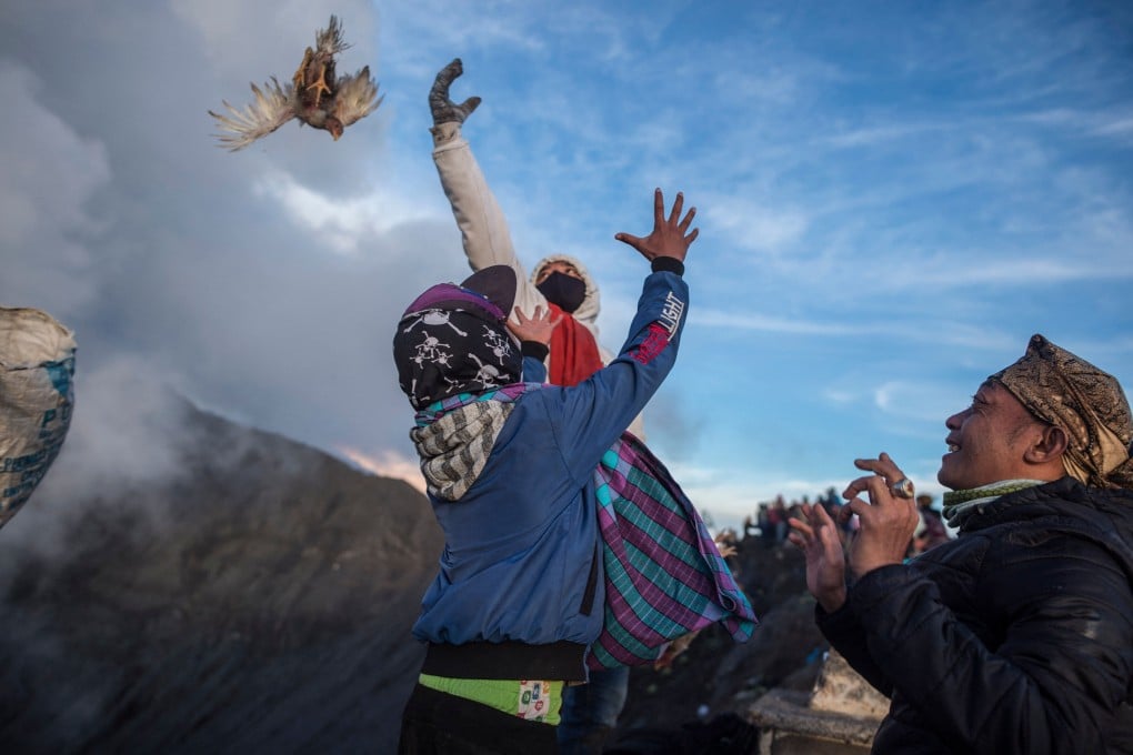 Members of the Tengger tribe throw their offerings into the crater of the active Mount Bromo volcano in Probolinggo, East Java province on Saturday. Photo: AFP