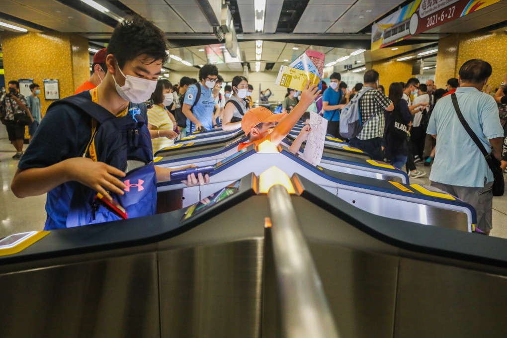 Happy MTR fans push through the turnstiles on their way to board the first train on the newly opened line. Photo: Xiaomei Chen