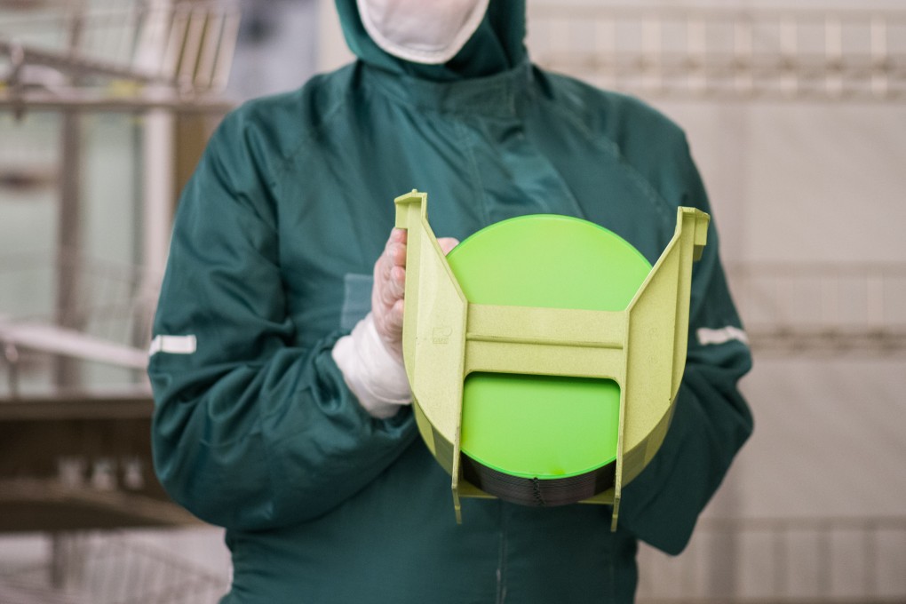 A worker holds a rack of silicon wafers at a semiconductor plant. There were nearly 512,000 people working in China’s chip industry at the end of 2019. Photo: Bloomberg