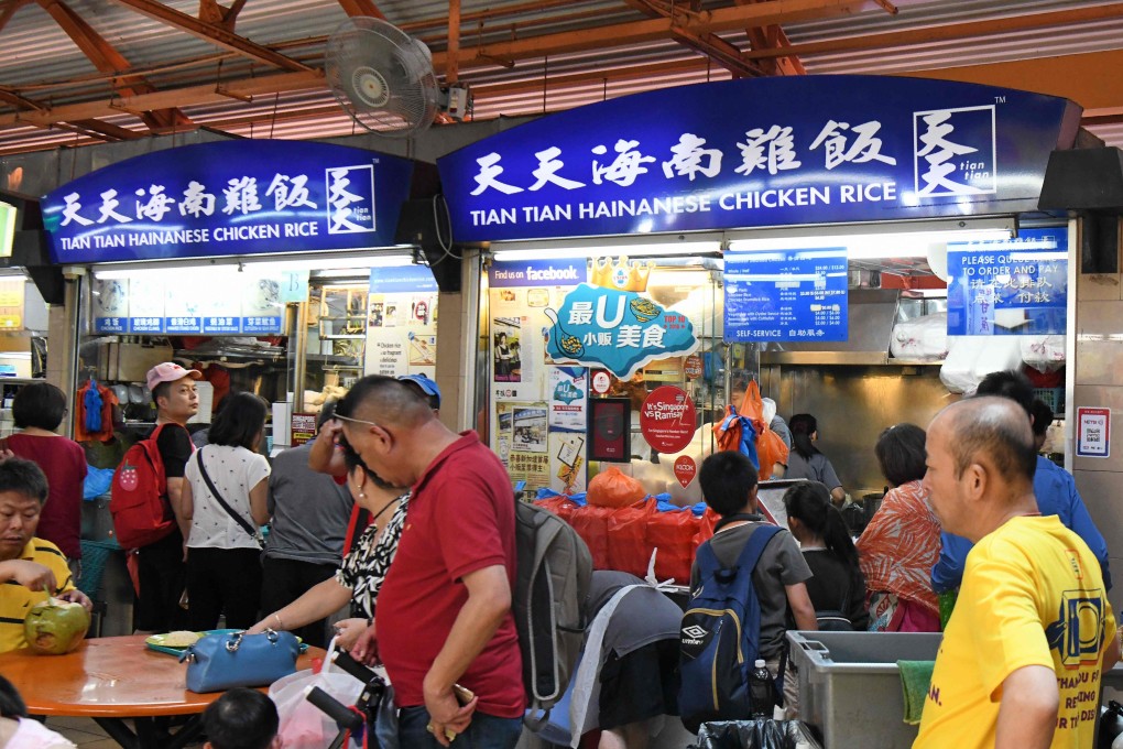 People eat at a hawker centre in Singapore. The country’s famed street food vendors suffered as a result of coronavirus curbs. Photo: AFP