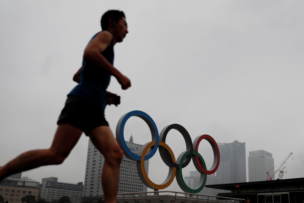 A jogger runs past the Olympic rings built to celebrate the postponed Tokyo 2020 Olympic Games in Yokohama in June. Photo: Reuters