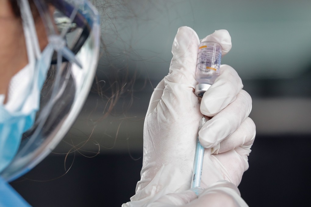 A health worker prepares a dose of a Sinovac Covid-19 jab at a car park in Manila. In the Philippines, 68 per cent of people are either uncertain or unwilling to take vaccines, a polling company found. Photo: EPA-EFE