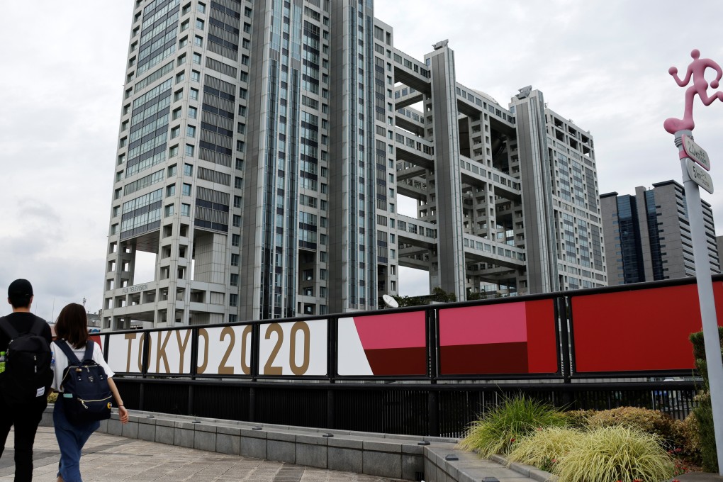 People walk past banners advertising the 2020 Tokyo Olympic Games. The Japanese capital is likely to be under emergency measures during the Games. Photo: Reuters