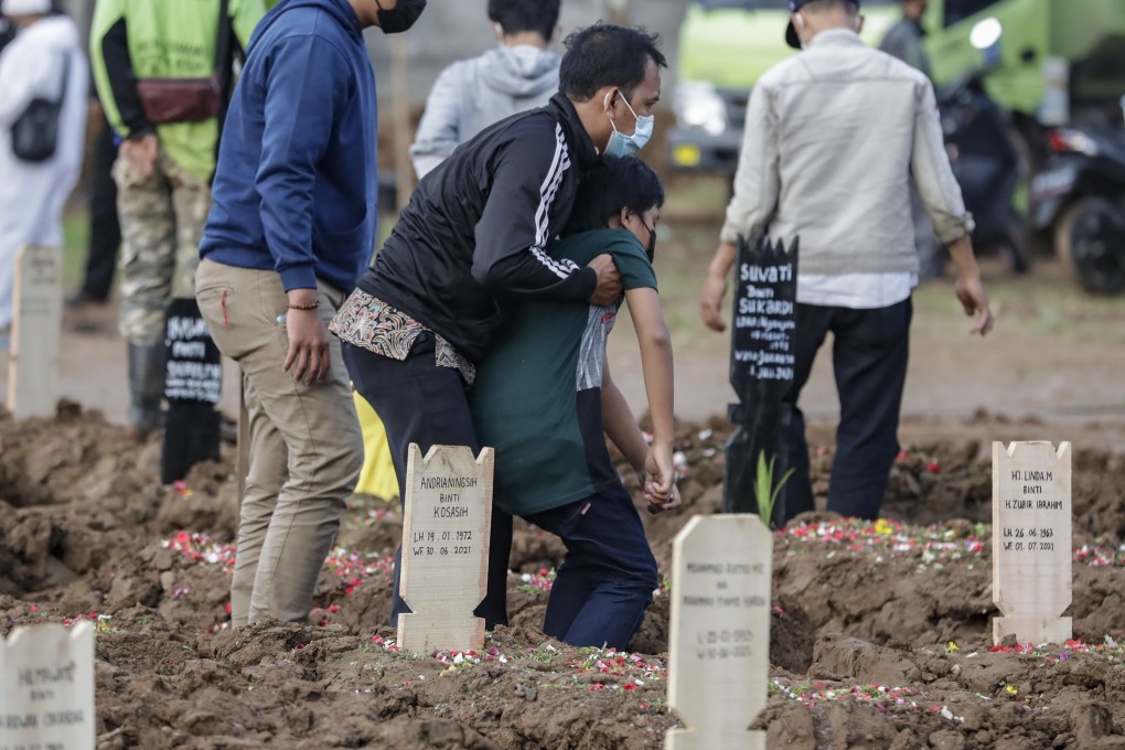 Relatives mourn by the grave of a Covid-19 victim during a funeral at Jakarta cemetery. Photo: EPA