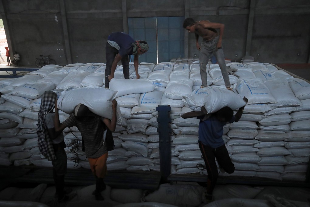 Porters unload food aid bound for victims of war after a checkpoint leading to Tigray in Mai Tsebri town in Ethiopia. PhotoL Reuters