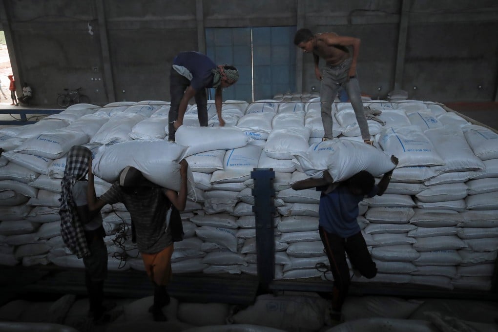Porters unload food aid bound for victims of war after a checkpoint leading to Tigray in Mai Tsebri town in Ethiopia. PhotoL Reuters