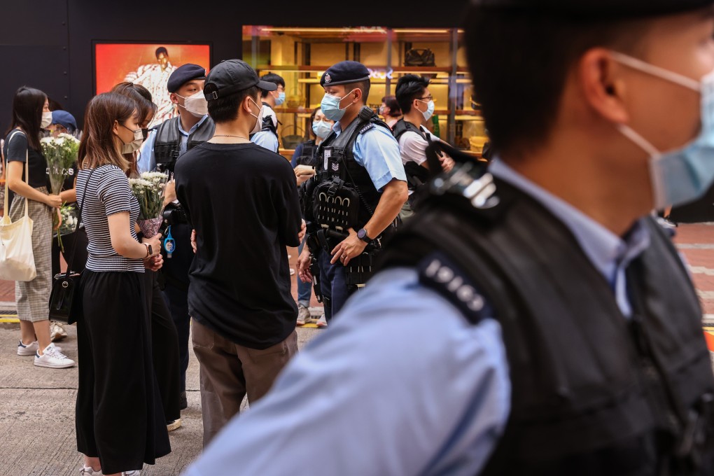 Police stop and search people going to lay flowers at East Point Road on Friday. Photo: K.Y. Cheng