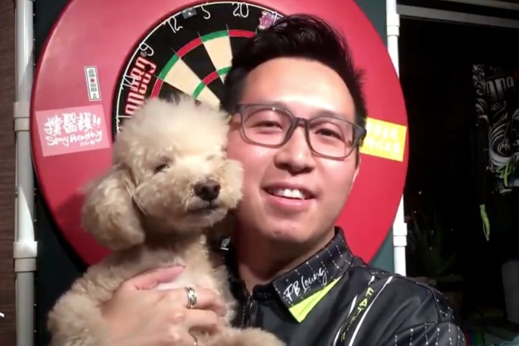 Hong Kong’s Kevin Leung Kai-fun with his dog Bauble after an online match on the PDC Tour. Photo: PDC