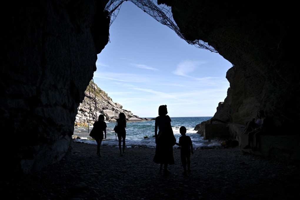 Tourists walk into a cave near the sea in Vernazza, Italy. Photo: AFP