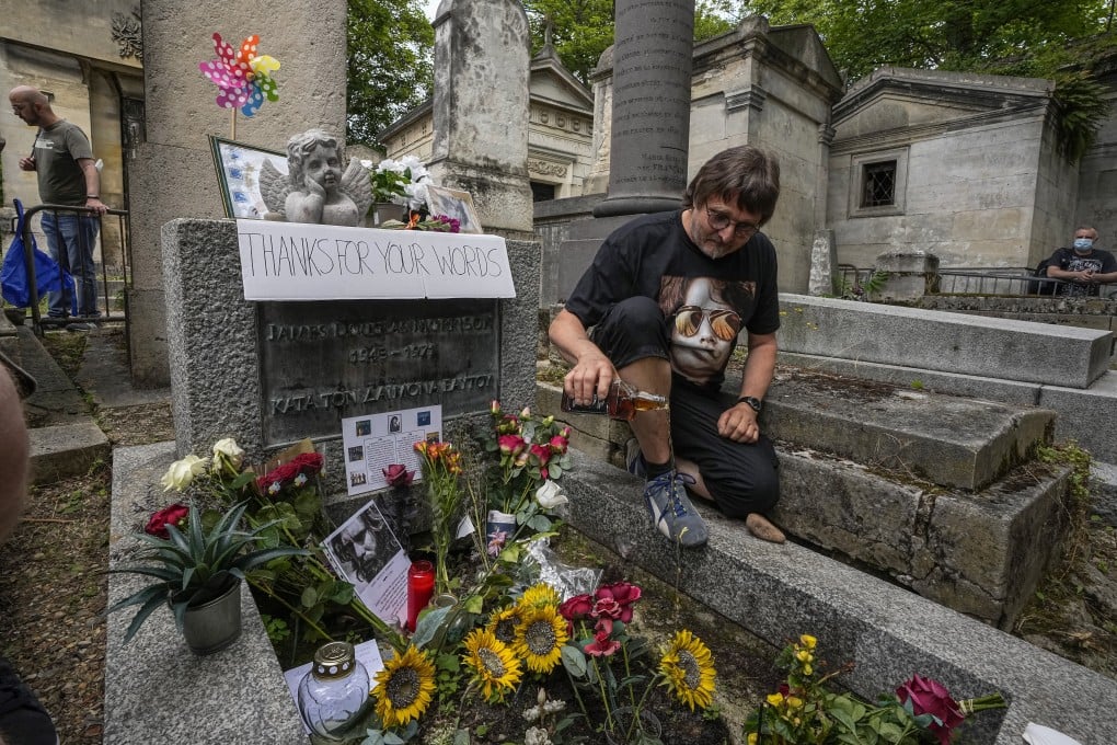 A German fan pours whisky on the tomb of musician Jim Morrison at the Pere Lachaise cemetery in Paris on Saturday. Photo: AP