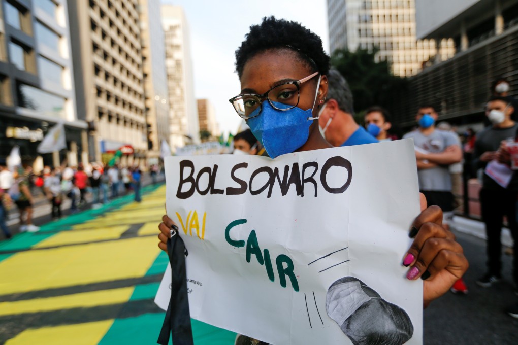 A protester holds a placard reading ‘Bolsonaro is going to fall’ in Sao Paulo, Brazil on Saturday. Photo: Reuters