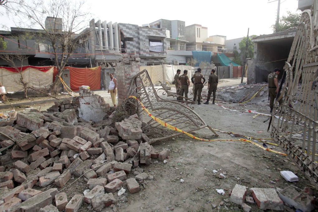 Pakistani security officials inspect the scene a day after a bomb blast near the residence of Hafiz Saeed, head of banned Islamic charity Jamat ud Dawa, in Lahore. At least three people were killed and 24 others were injured. Photo: EPA-EFE