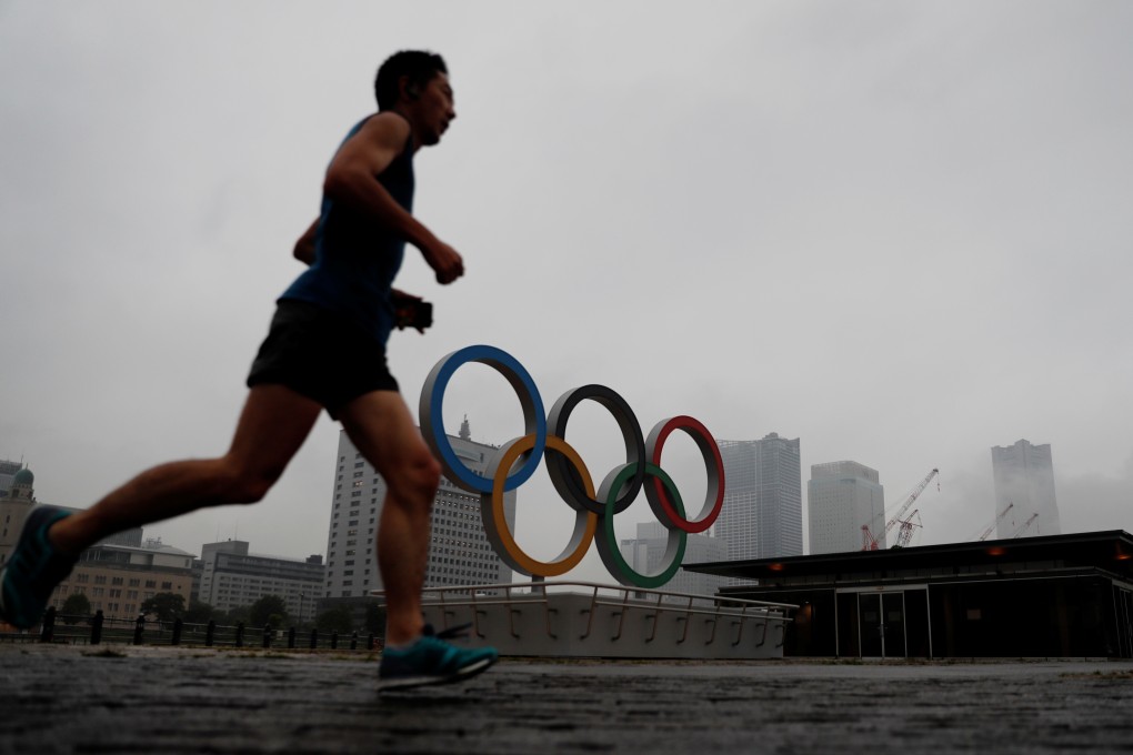 A jogger runs past a newly installed Olympic rings in Yokohama, Japan. Photo: Reuters
