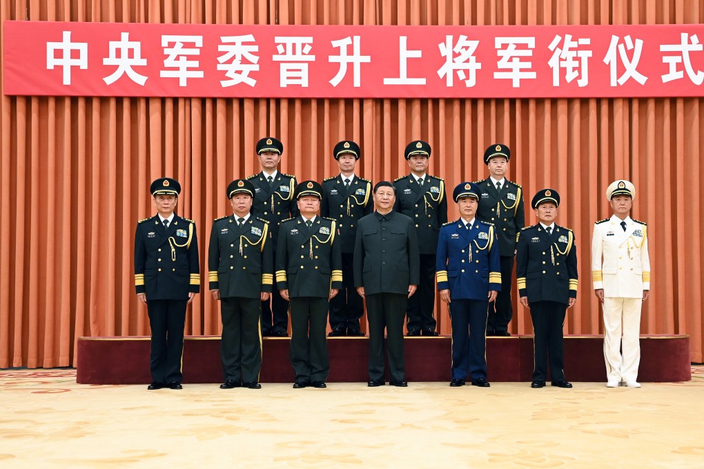 Xi Jinping, chairman of the Central Military Commission, poses with military officials including the four promoted senior officers. Photo: Xinhua