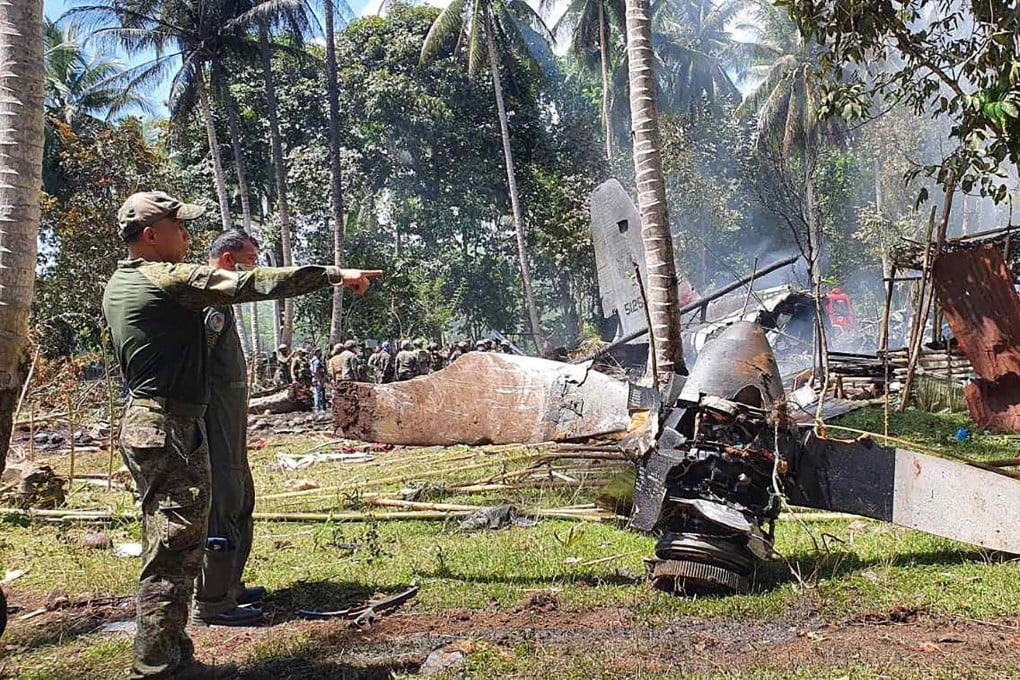Philippine military officials inspect the scene after an air force C-130 transport plane crashed near the airport in Jolo town, Sulu province. Photo: AFP.”