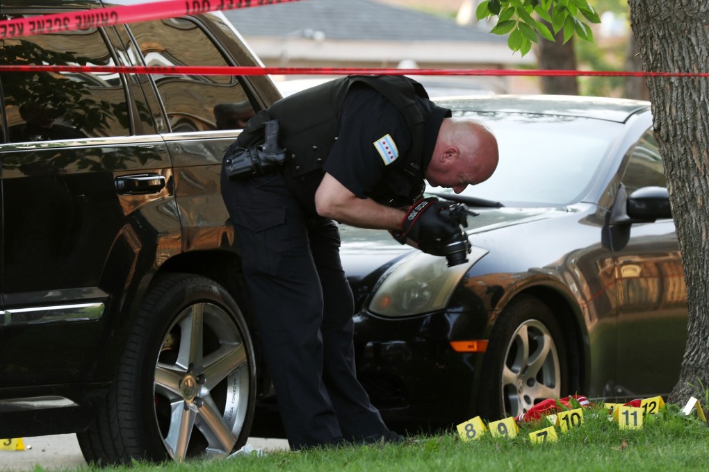 A police officer photographs bullet casings at the scene of a fatal shooting in Chicago. Photo: Chicago Tribune / TNS
