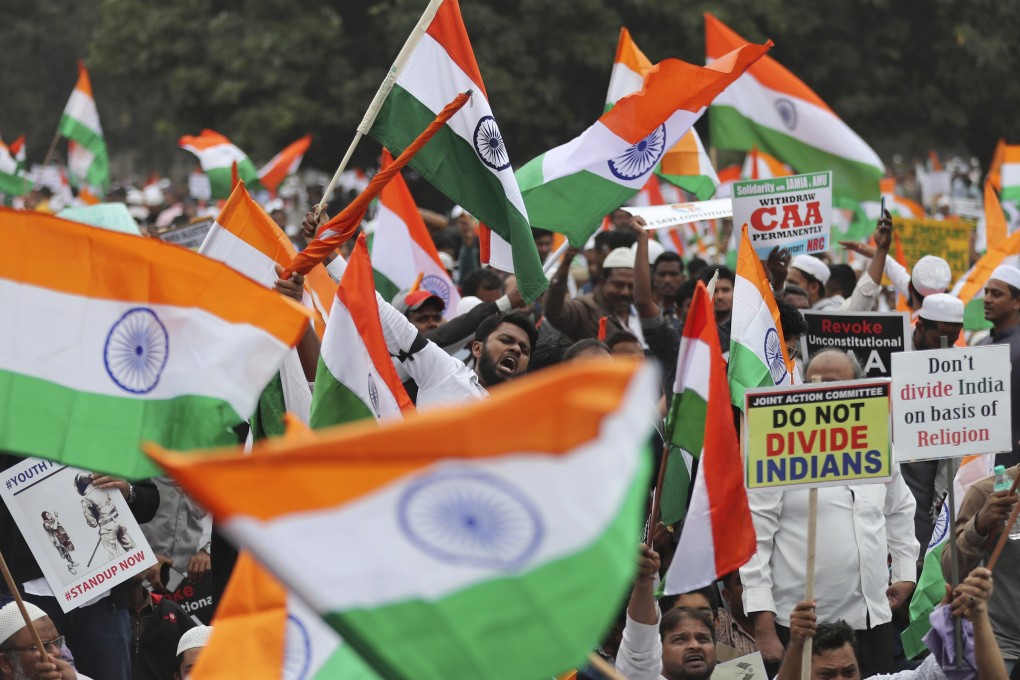 Indians hold national flags and placards during a protest against a 2019 citizenship law introduced by the BJP government that fast-tracked citizenship for refugees of other religions but not Muslims. Photo: AP