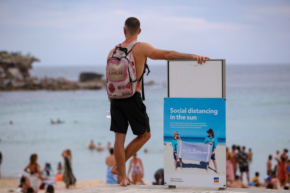 A man stands beside a notice board at Bondi Beach, Sydney, in January. Photo: Xinhua